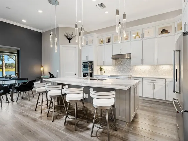 a living room with furniture a floor to ceiling window and potted plants