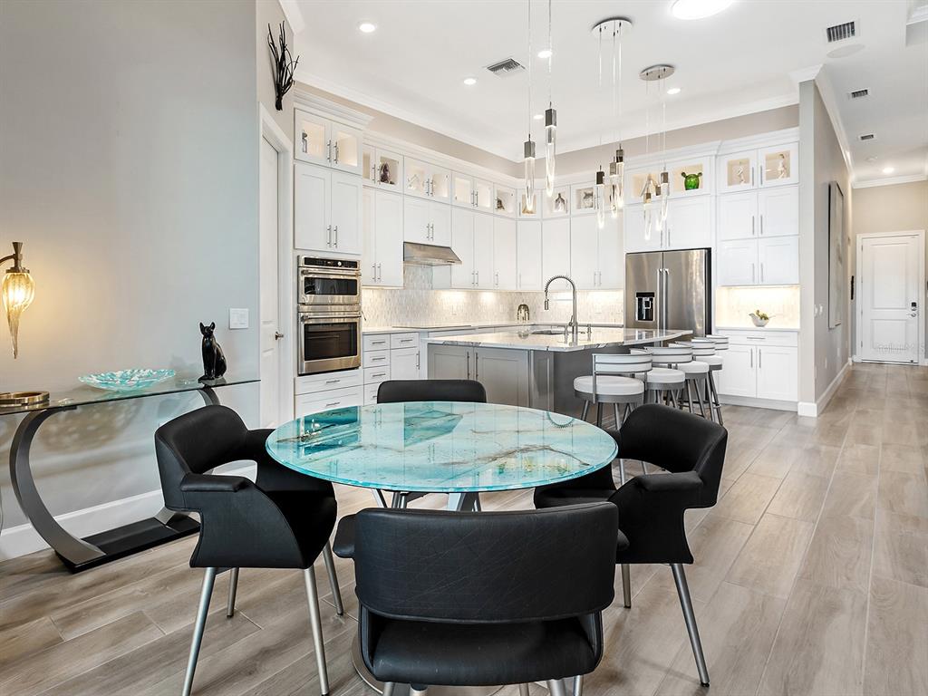 17807 Eastbrook Terrace Lakewood Ranch, FL 34202 - Photo 33 of 92 a dining table with chairs and kitchen view