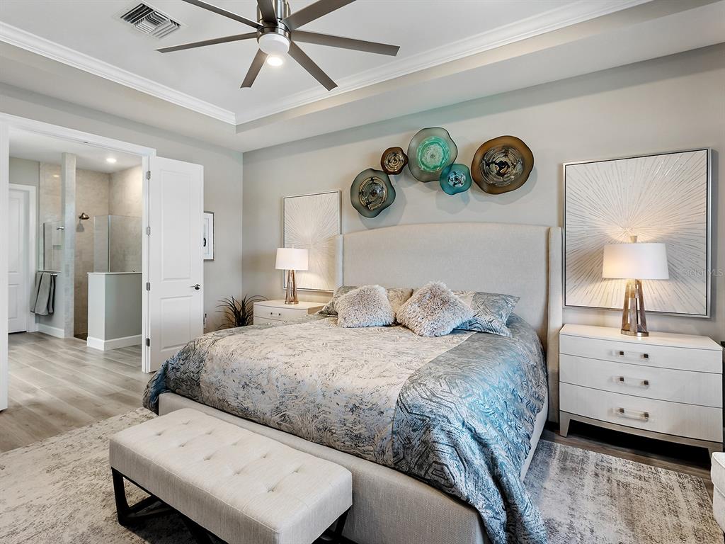 17807 Eastbrook Terrace Lakewood Ranch, FL 34202 - Photo 39 of 92 a bedroom with a bed and a chandelier