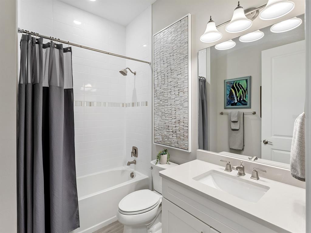 17807 Eastbrook Terrace Lakewood Ranch, FL 34202 - Photo 48 of 92 a bathroom with a granite countertop sink a toilet and shower