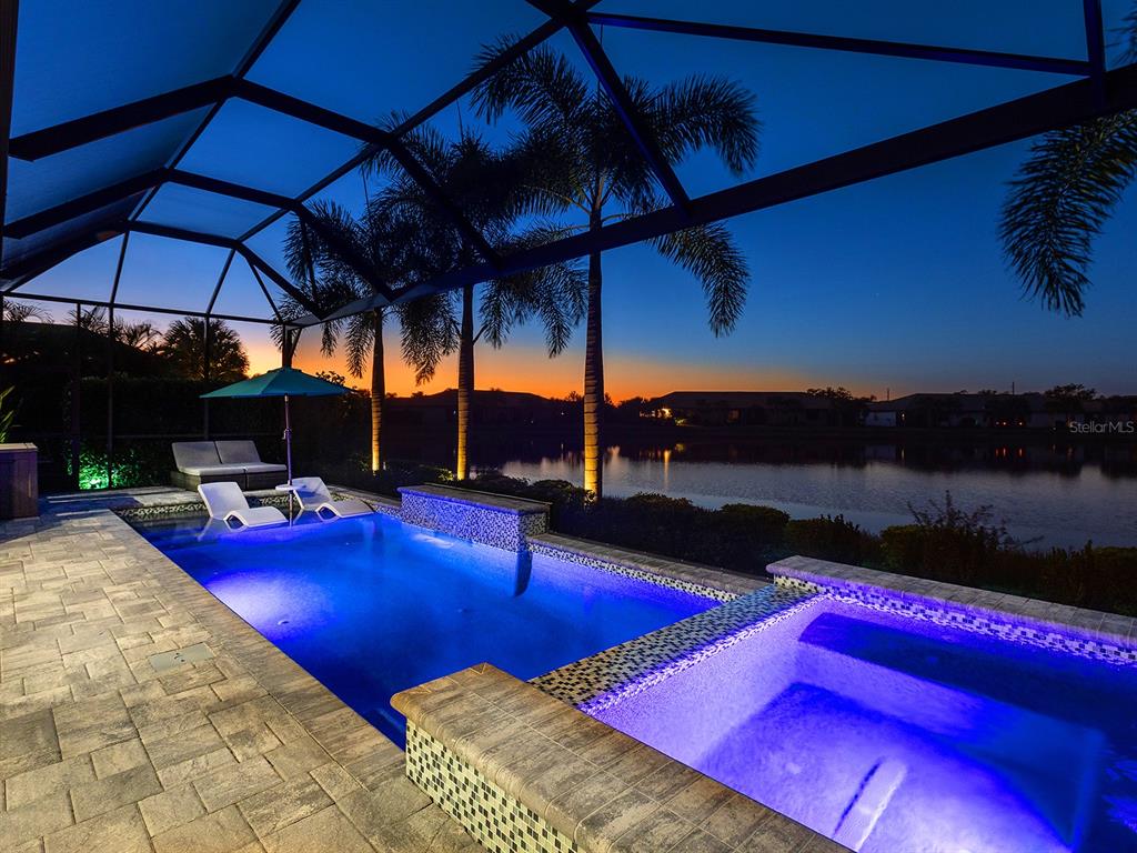 17807 Eastbrook Terrace Lakewood Ranch, FL 34202 - Photo 6 of 92 a view of swimming pool with a table and chairs under an umbrella