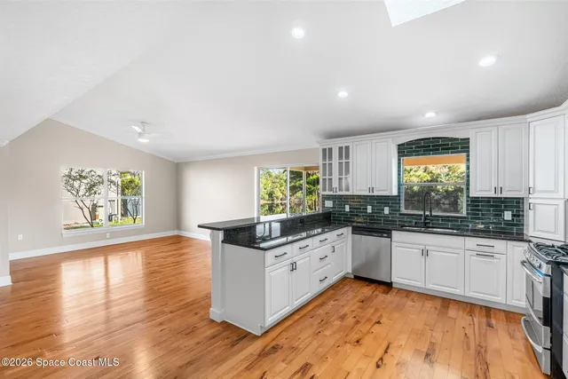 a kitchen with stainless steel appliances granite countertop a refrigerator and a stove top oven