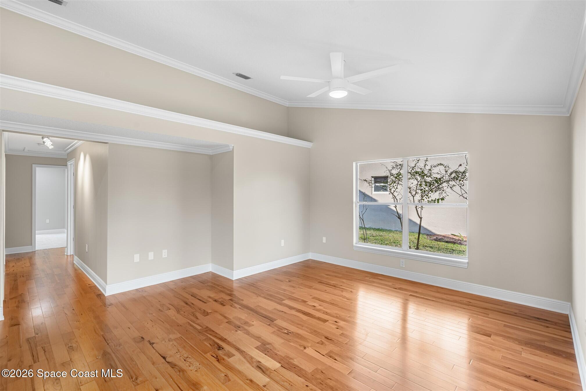 8033 Kingswood Way Melbourne, FL 32940 - Photo 30 of 70 a view of an empty room with wooden floor and a window