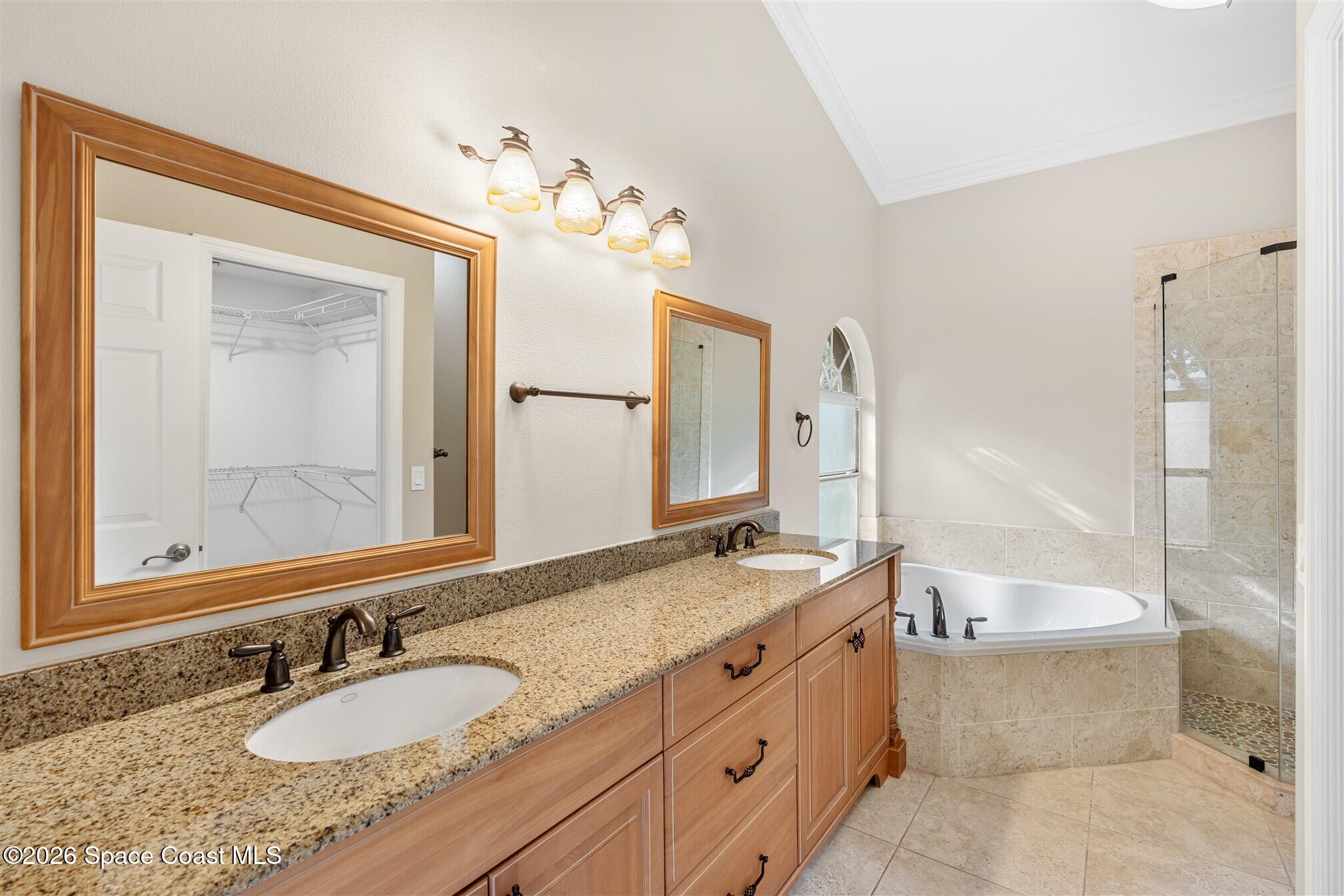 8033 Kingswood Way Melbourne, FL 32940 - Photo 35 of 70 a bathroom with a granite countertop tub a double vanity sink and a mirror