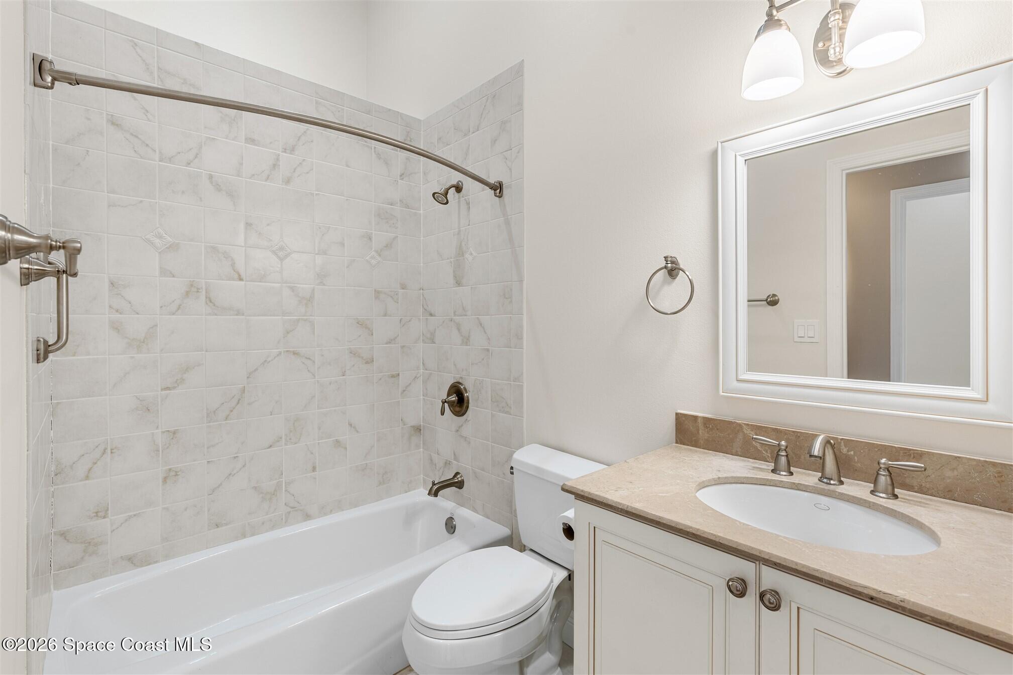 8033 Kingswood Way Melbourne, FL 32940 - Photo 43 of 70 a bathroom with a granite countertop sink a toilet and shower
