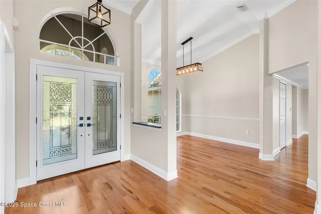 a view of a hallway with wooden floor and a bathroom