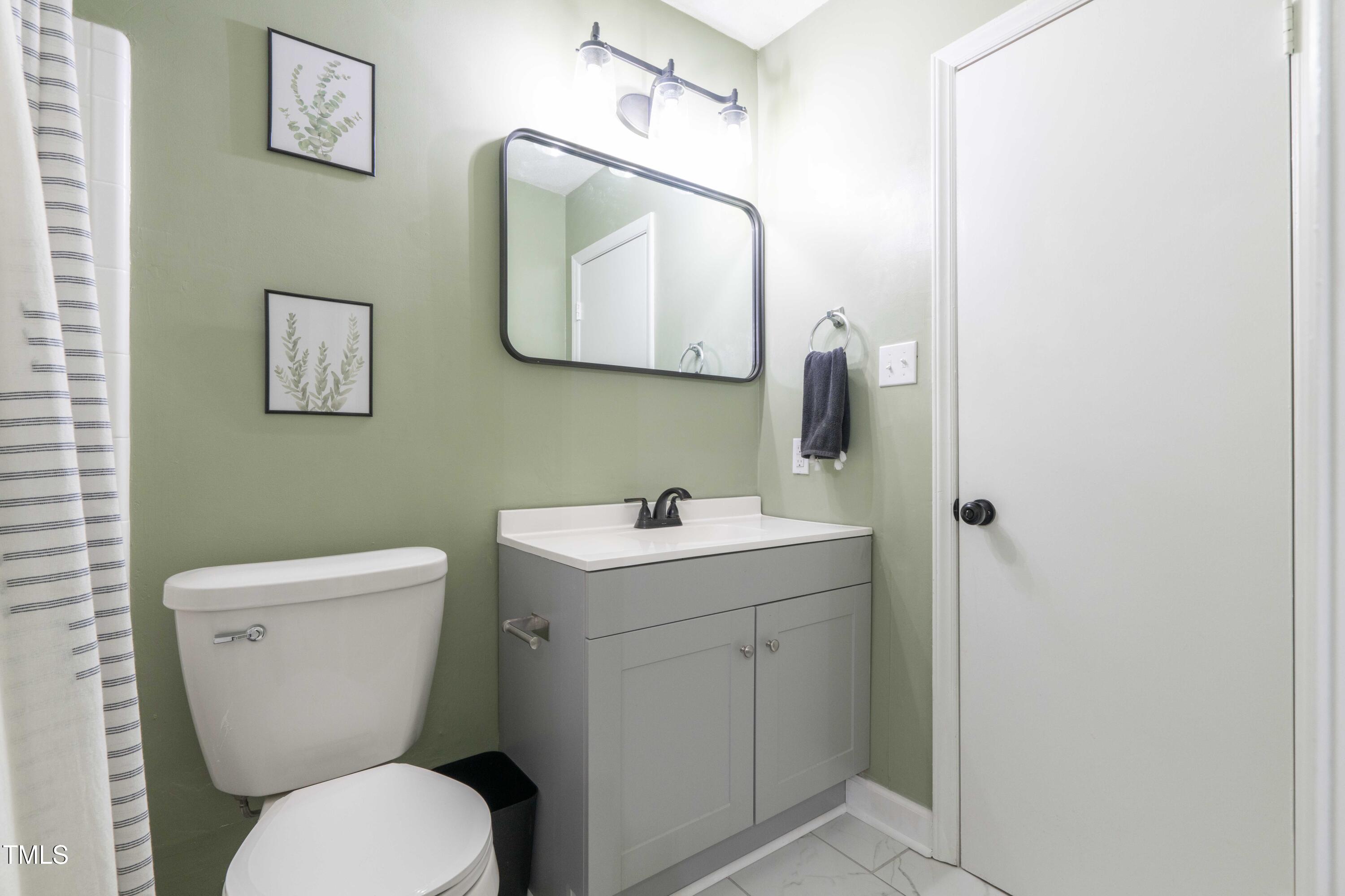 1316 Garden Crest Circle Raleigh, NC 27609 - Photo 38 of 46 a bathroom with a toilet sink and mirror