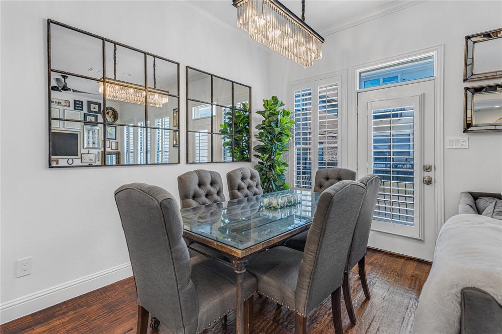5744 Robbie Road Plano, TX 75024 - Photo 13 of 32 Dining area featuring rich wood-finish flooring, a contemporary chandelier, two panel mirrors, and a door with an upper transom window