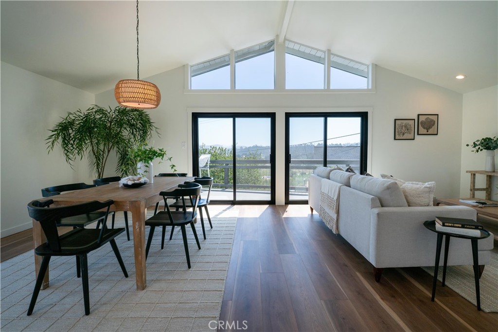 675 Huntington Road Cambria, CA 93428 - Photo 8 of 30 a living room with furniture a wooden floor and a floor to ceiling window