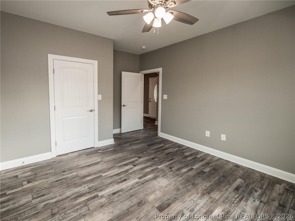 1102 West Carthage Road Lumberton, NC 28360 - Photo 31 of 41 a view of an empty room with wooden floor and a ceiling fan