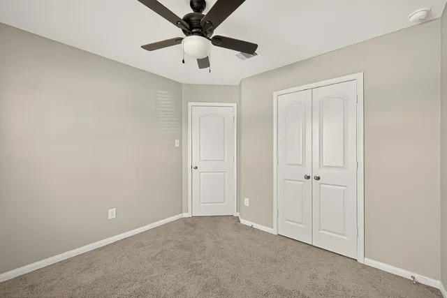 an empty room with chandelier fan