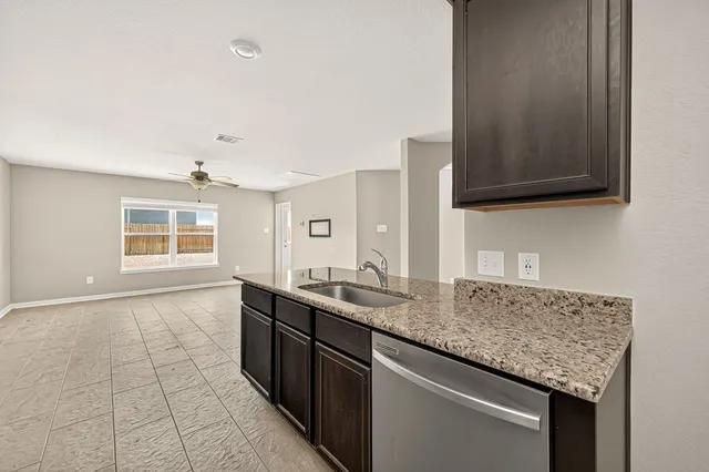 a kitchen with granite countertop a sink and a stove