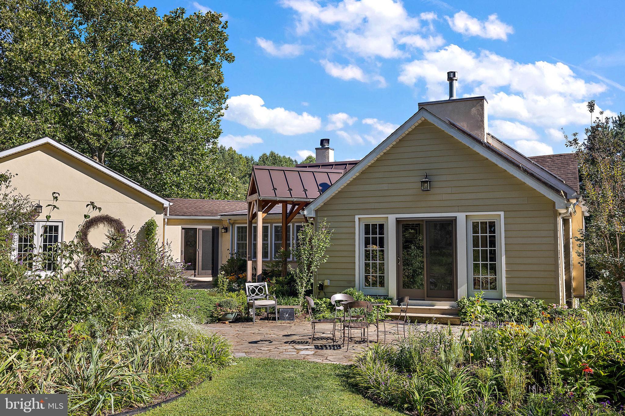 126 Ridge Road Chadds Ford, PA 19317 - Photo 3 of 64 a backyard of a house with table and chairs with potted plants and a large tree