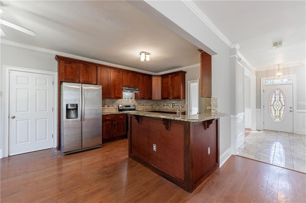 6790 Palace Lane Fairburn, GA 30213 - Photo 22 of 62 a kitchen with stainless steel appliances granite countertop a refrigerator a sink dishwasher a stove with wooden cabinets and a large window