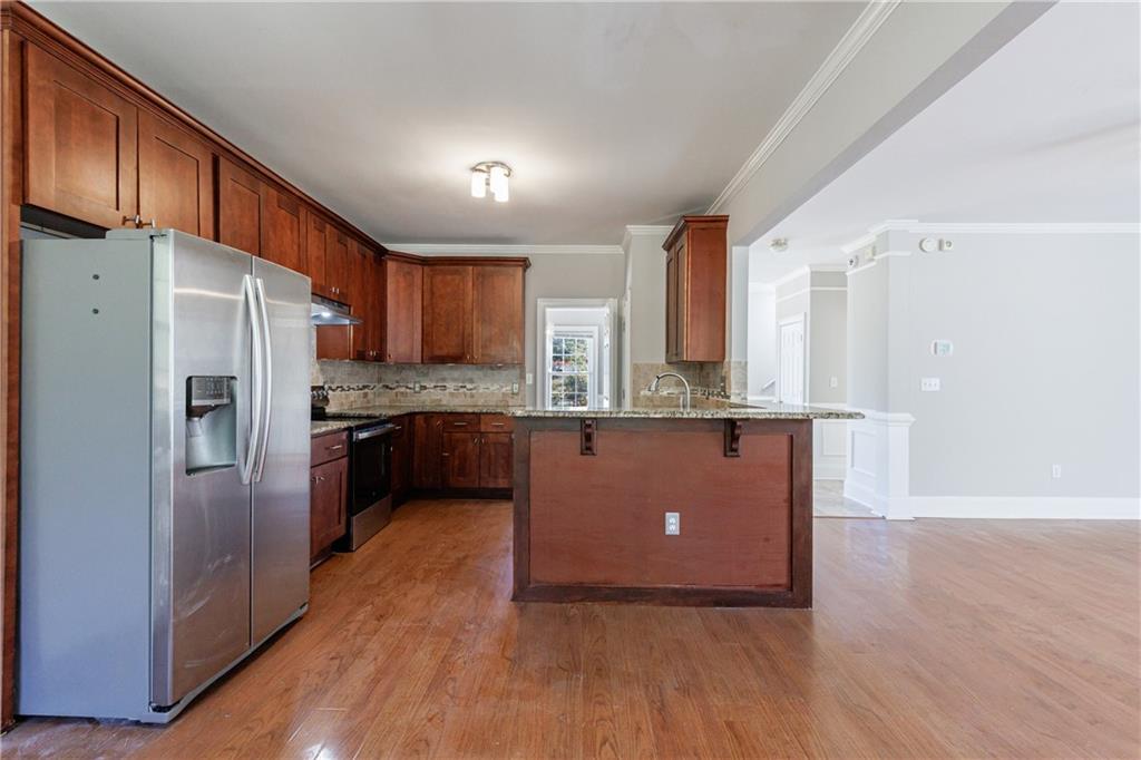 6790 Palace Lane Fairburn, GA 30213 - Photo 26 of 62 a kitchen with stainless steel appliances a refrigerator and a wooden floor