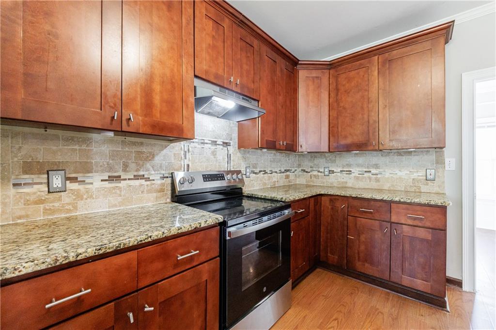 6790 Palace Lane Fairburn, GA 30213 - Photo 27 of 62 a kitchen with granite countertop stainless steel appliances a stove a sink and a microwave