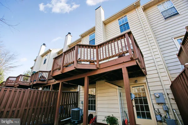a view of a house with wooden deck front of house