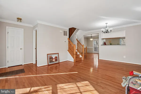 a view of a livingroom with wooden floor and stairs