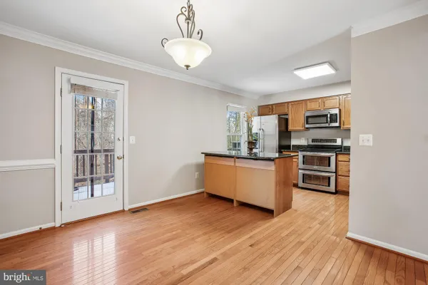 a kitchen with stainless steel appliances granite countertop a stove and a wooden floors