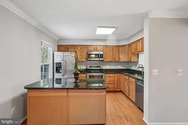 a kitchen with stainless steel appliances granite countertop a refrigerator and a stove top oven
