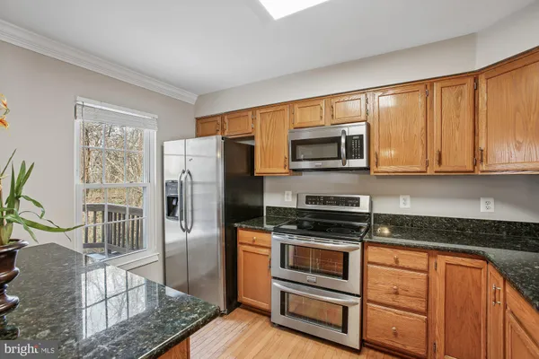 a kitchen with granite countertop a refrigerator stove and microwave