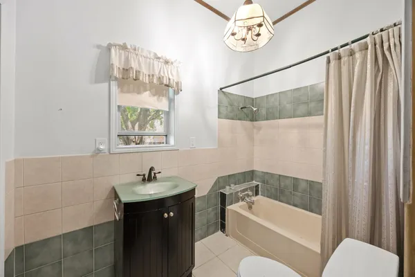 a bathroom with a sink vanity mirror and bathtub