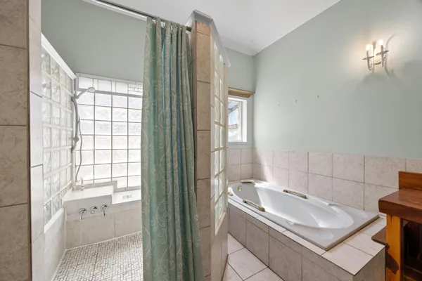 a bathroom with a tub sink and mirror