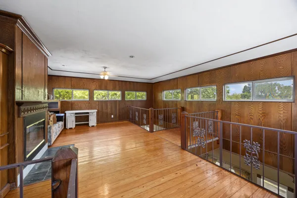 an empty room with floor to ceiling window and an outdoor kitchen