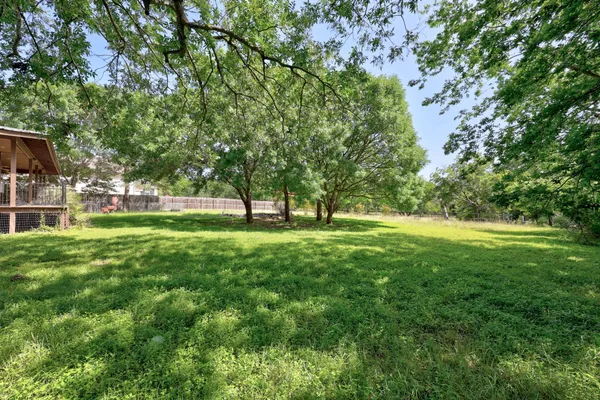 a view of green field with trees in the background