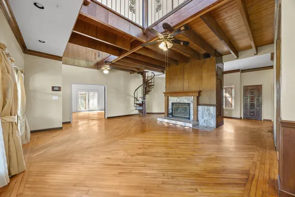 a view of empty room with wooden floor and fireplace