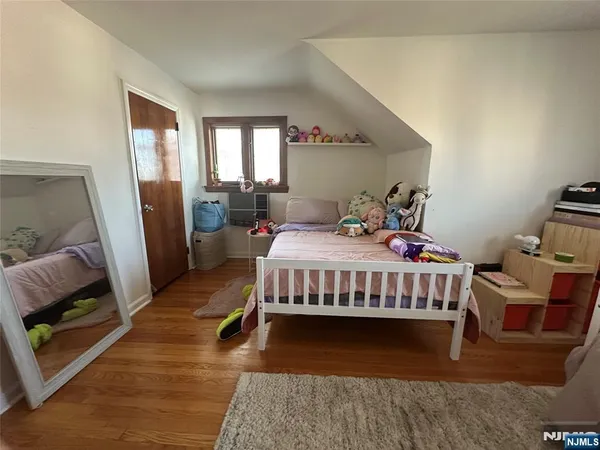 a bedroom with a bed and a mirror on the dresser