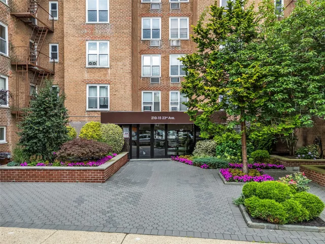 a view of a brick house with a yard and potted plants