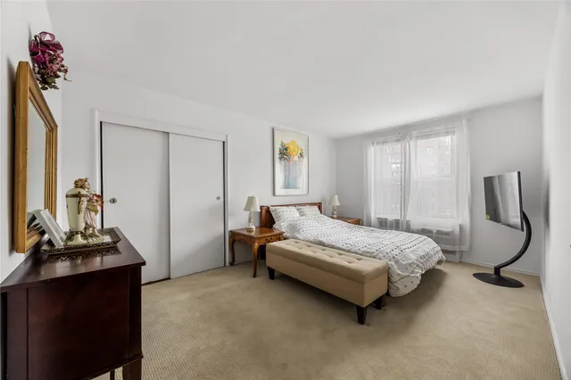 a bedroom with a bed window and chair