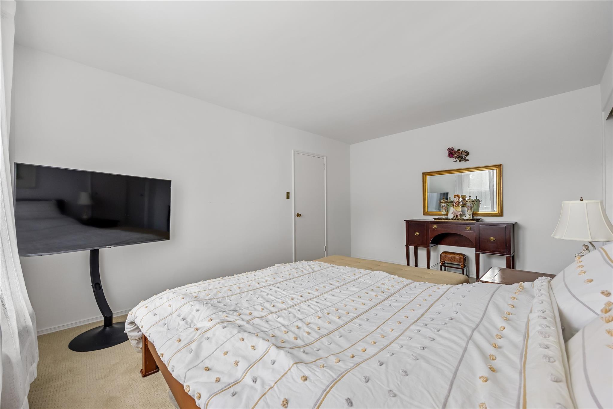 210-15 23rd Avenue, Unit 3B Queens, NY 11360 - Photo 13 of 18 a bedroom with a bed and a flat screen tv