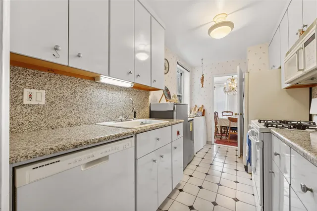 a kitchen with granite countertop a sink stove and cabinets