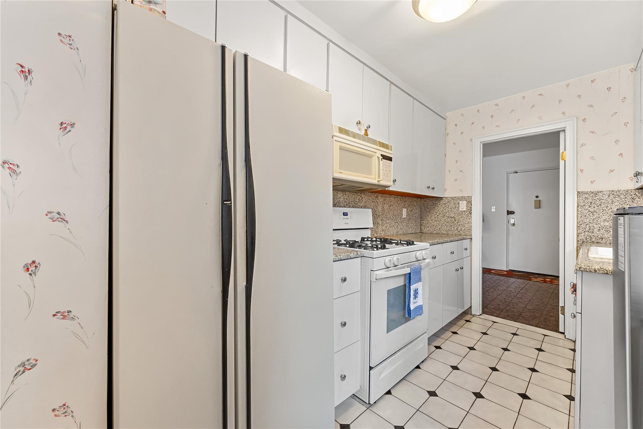210-15 23rd Avenue, Unit 3B Queens, NY 11360 - Photo 10 of 18 a kitchen with stainless steel appliances a refrigerator sink and stove