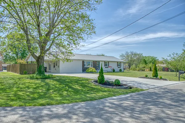a front view of a house with a yard and trees