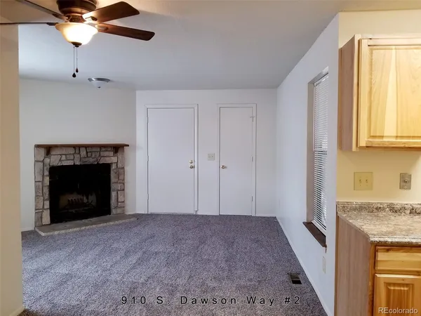 a view of an empty room with a fireplace and a window