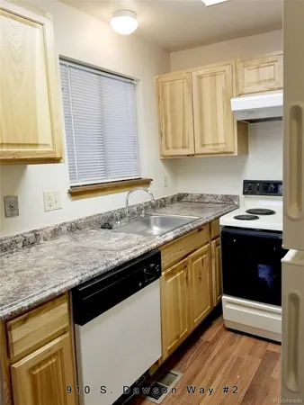 a kitchen with granite countertop a sink a stove and cabinets