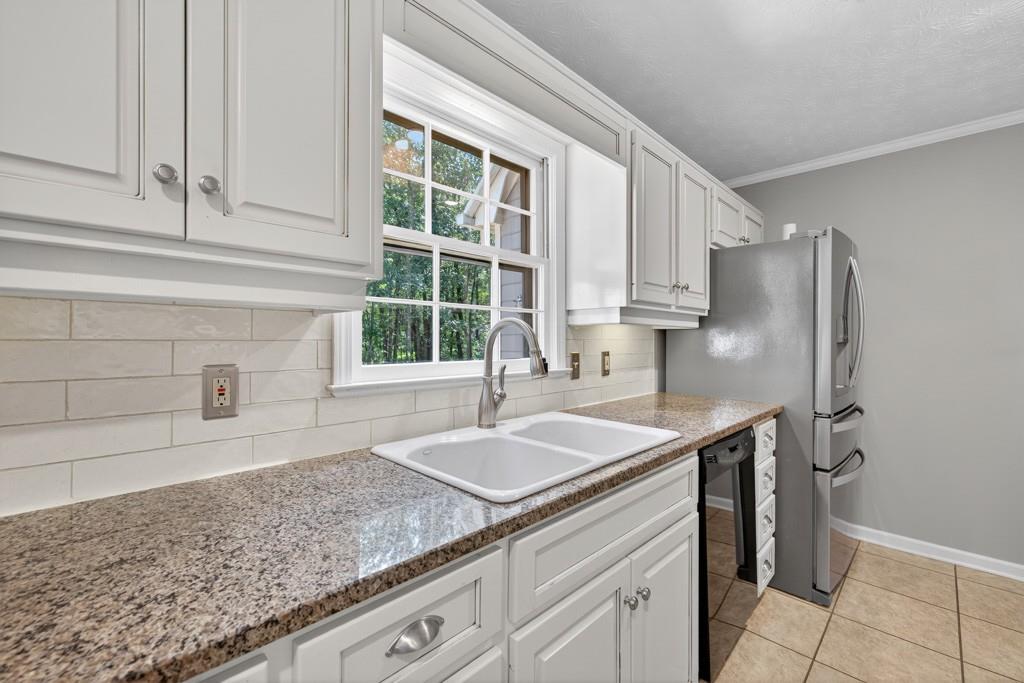 82 Cedar Bluff Winder, GA 30680 - Photo 26 of 47 a kitchen with granite countertop a sink and a refrigerator