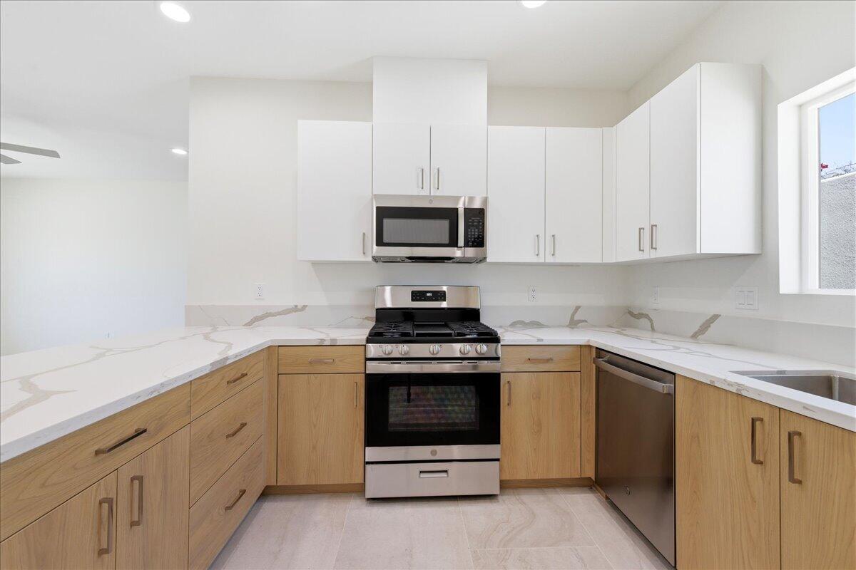 68160 Modalo Road Cathedral City, CA 92234 - Photo 42 of 57 a kitchen with granite countertop white cabinets and stainless steel appliances