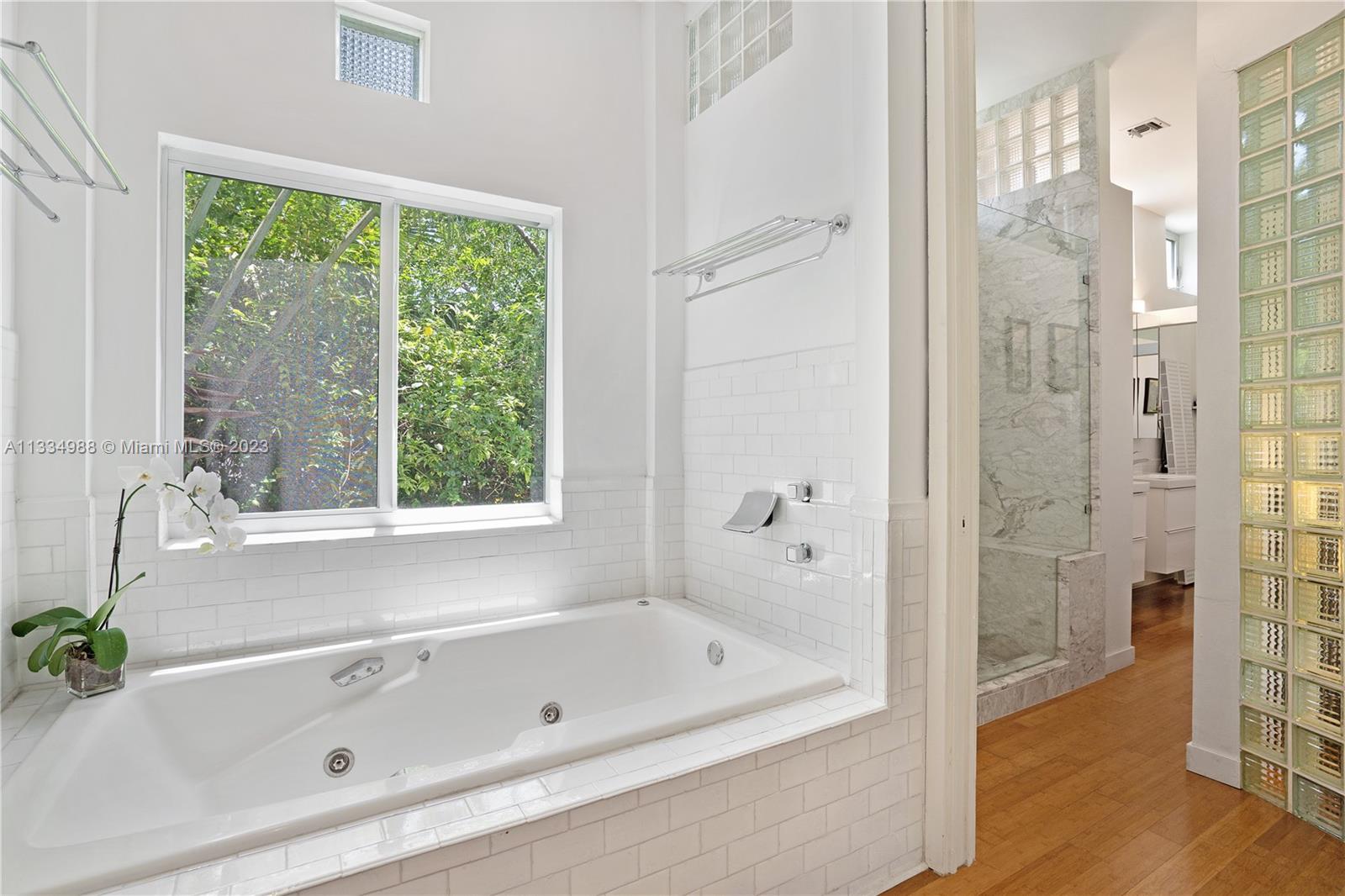 4091 Park Avenue Miami, FL 33133 - Photo 16 of 35 a bathroom with a tub a window and a shower