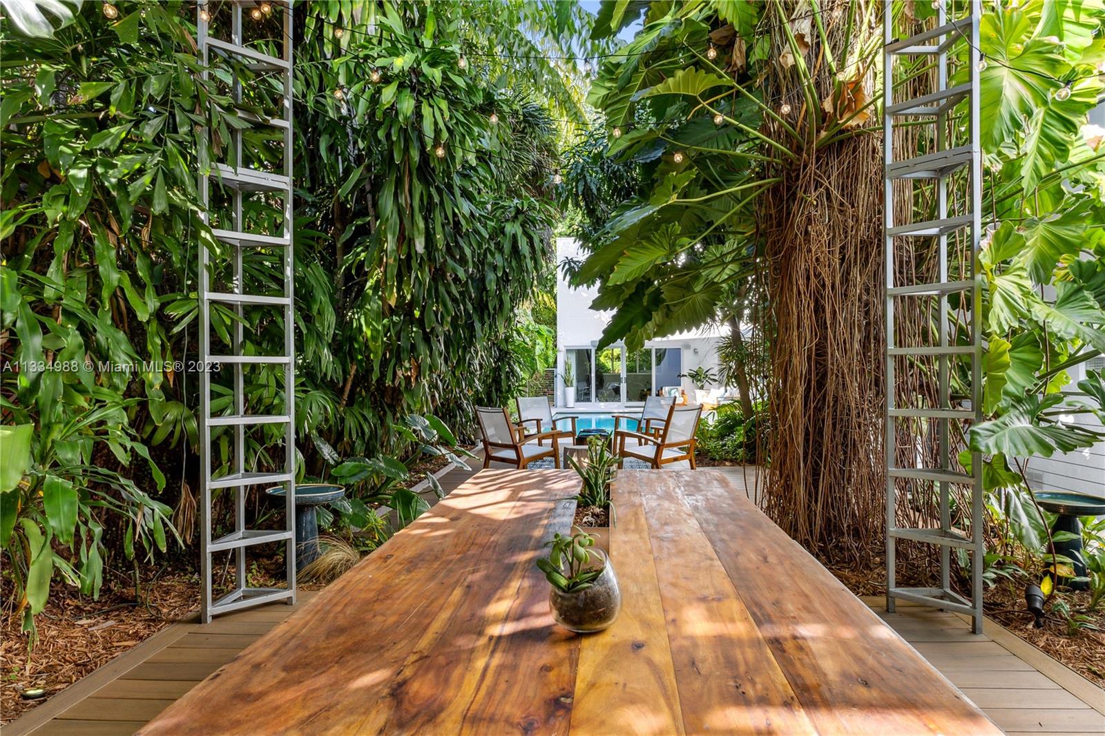 4091 Park Avenue Miami, FL 33133 - Photo 24 of 35 a backyard of a house with table and chairs a barbeque with potted plants and large trees