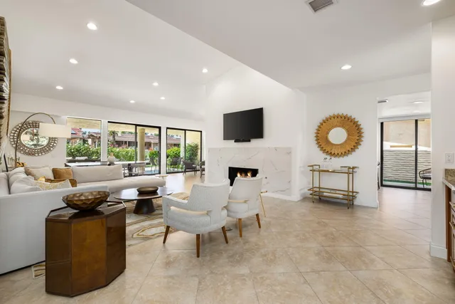 a kitchen with a sink refrigerator and chairs