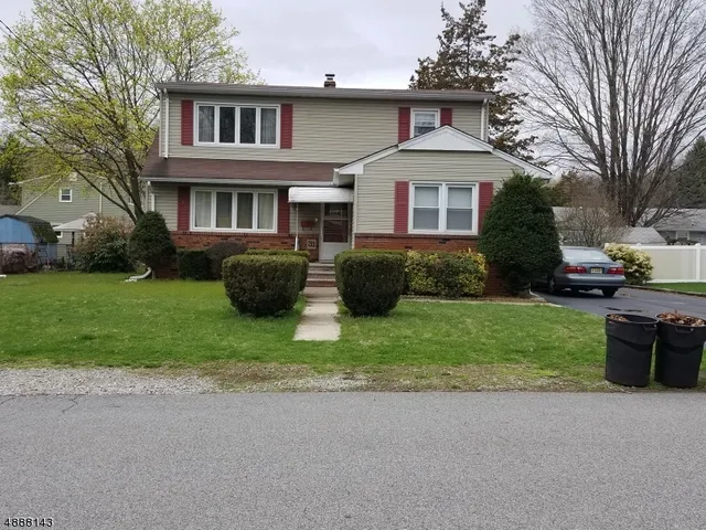 a front view of a house with a garden and plants