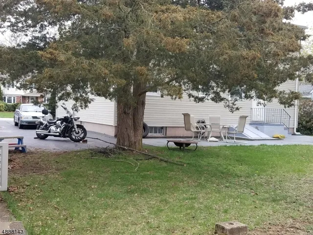 a view of a backyard with table and chairs and a large tree