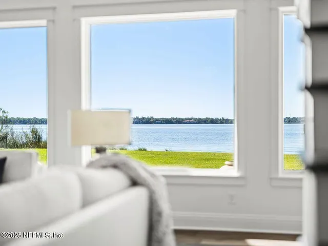 a spacious bedroom with a bed a window and a flat screen television
