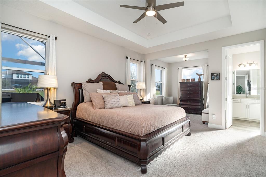 1904 146th Terrace East Parrish, FL 34219 - Photo 12 of 40 a spacious bedroom with a bed and a chandelier