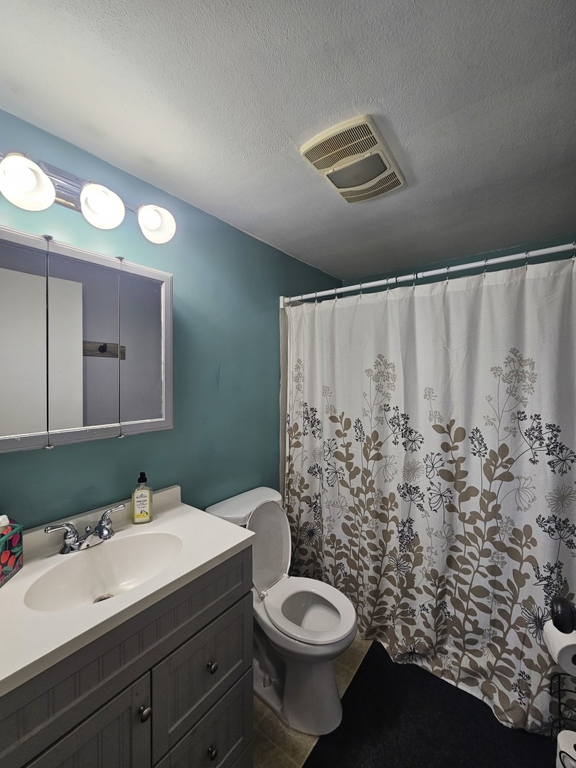 10N827 Hawthorne Street Elgin, IL 60123 - Photo 7 of 14 a bathroom with a sink and a mirror