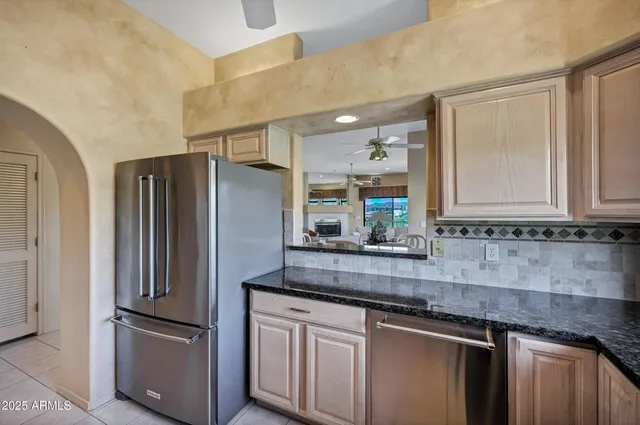 a kitchen with stainless steel appliances granite countertop a refrigerator and a sink